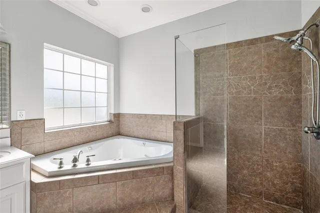 a bathroom with a tub a window and a shower