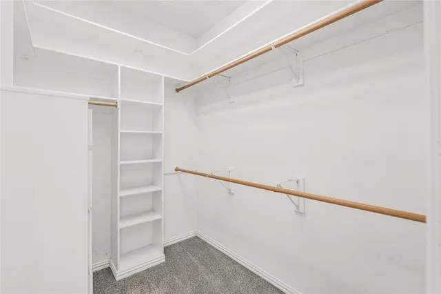 a view of walk in closet with empty racks