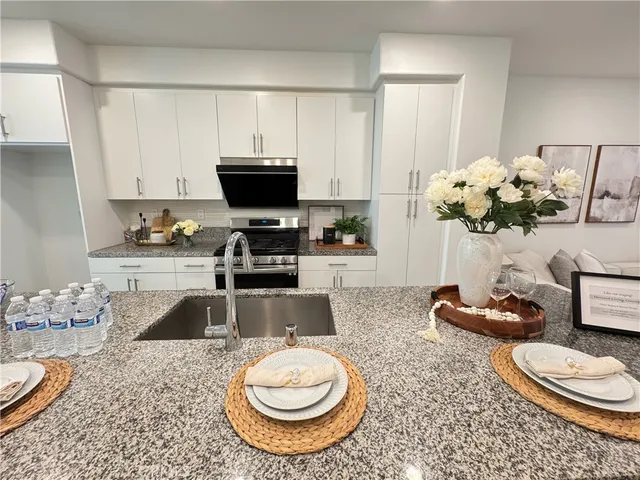 a kitchen with a sink a stove and a wooden floor