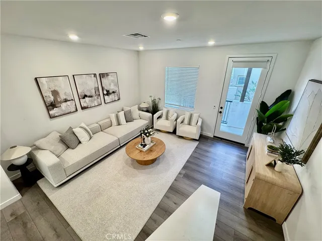 a living room with furniture rug and wooden floor