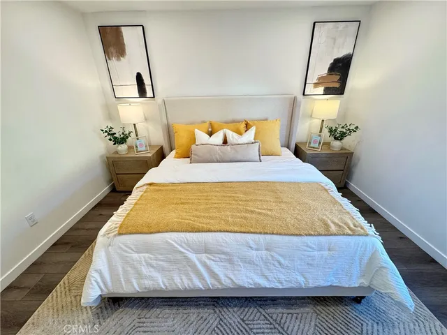 a bed sitting in a bedroom next to a window with potted plant