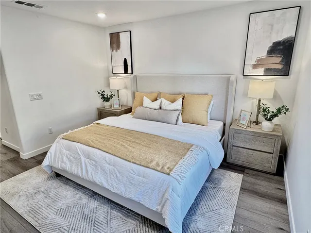 a bedroom with a bed lamp and a mirror