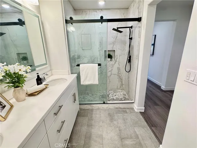 a bathroom with a granite countertop shower sink and mirror