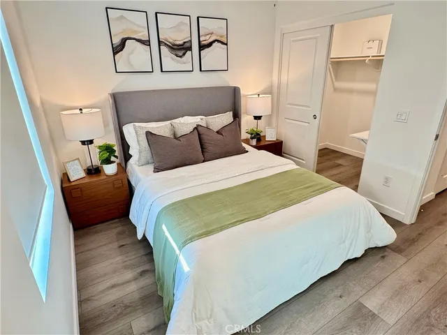 a bedroom with a bed and wooden floor