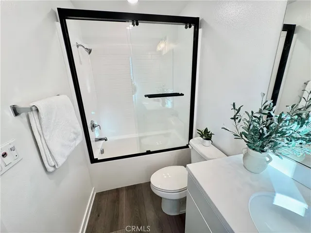 a white toilet sitting next to a shower