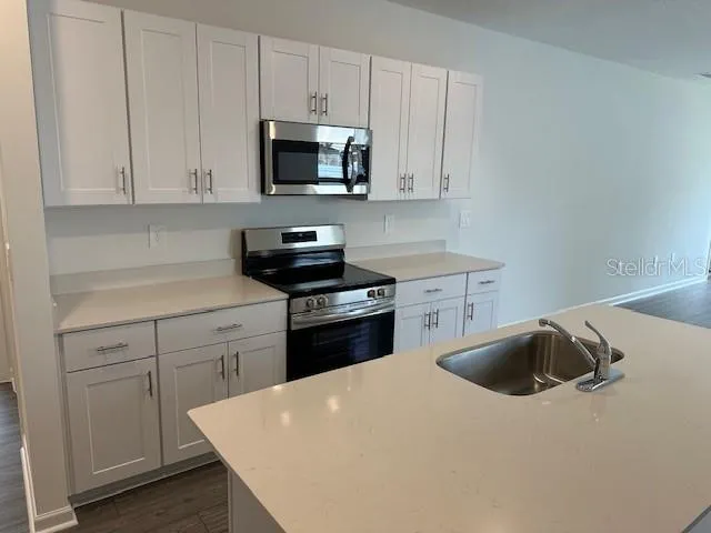 a kitchen with white cabinets and stainless steel appliances