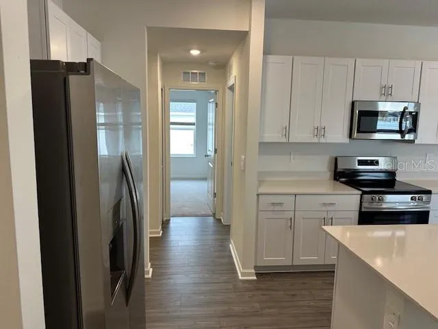 a kitchen with white cabinets and stainless steel appliances