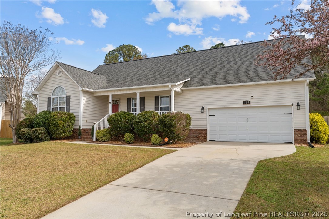 115 Shelby Street Spring Lake, NC 28390 - Photo 2 of 40 a front view of a house with a yard and garage