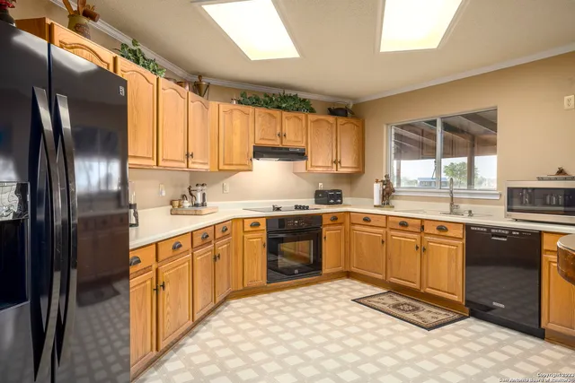 a kitchen with stainless steel appliances granite countertop a stove a sink dishwasher a refrigerator and cabinets with wooden floor