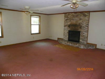 96770 Chester Road Yulee, FL 32097 - Photo 4 of 12 an empty room with windows and fireplace