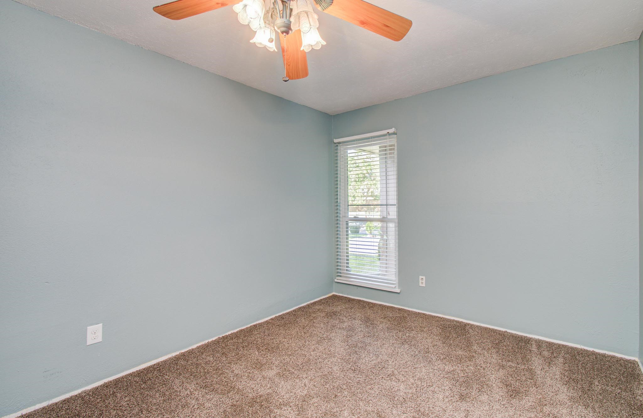 5706 Spring Grove Lane Spring, TX 77373 - Photo 5 of 12 an empty room with a chandelier fan and windows