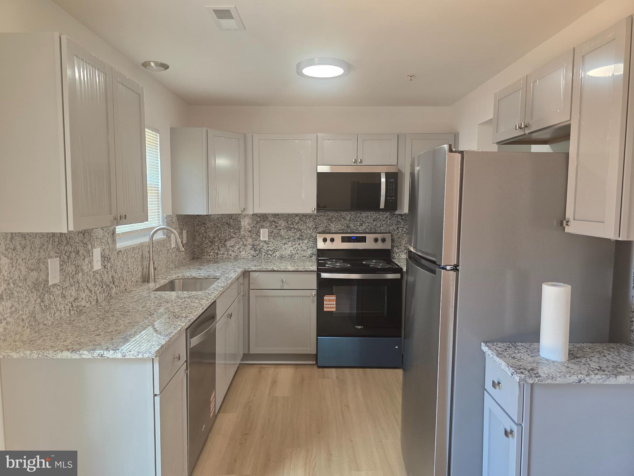 8839 Ritchboro Road District Heights, MD 20747 - Photo 4 of 12 a kitchen with a refrigerator and a sink