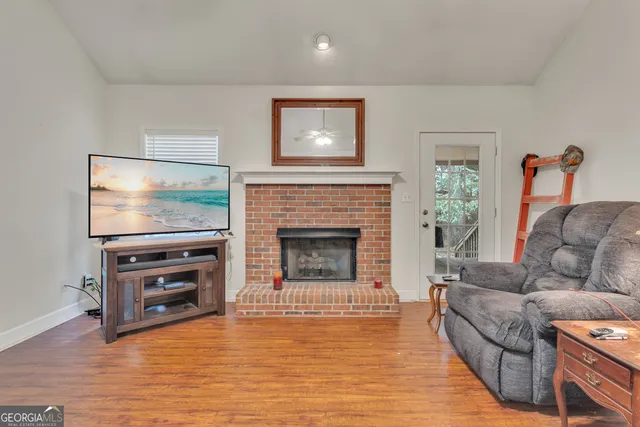 a living room with furniture a flat screen tv and a fireplace