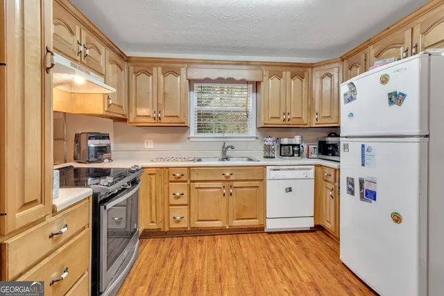 a kitchen with stainless steel appliances granite countertop a stove and white cabinets