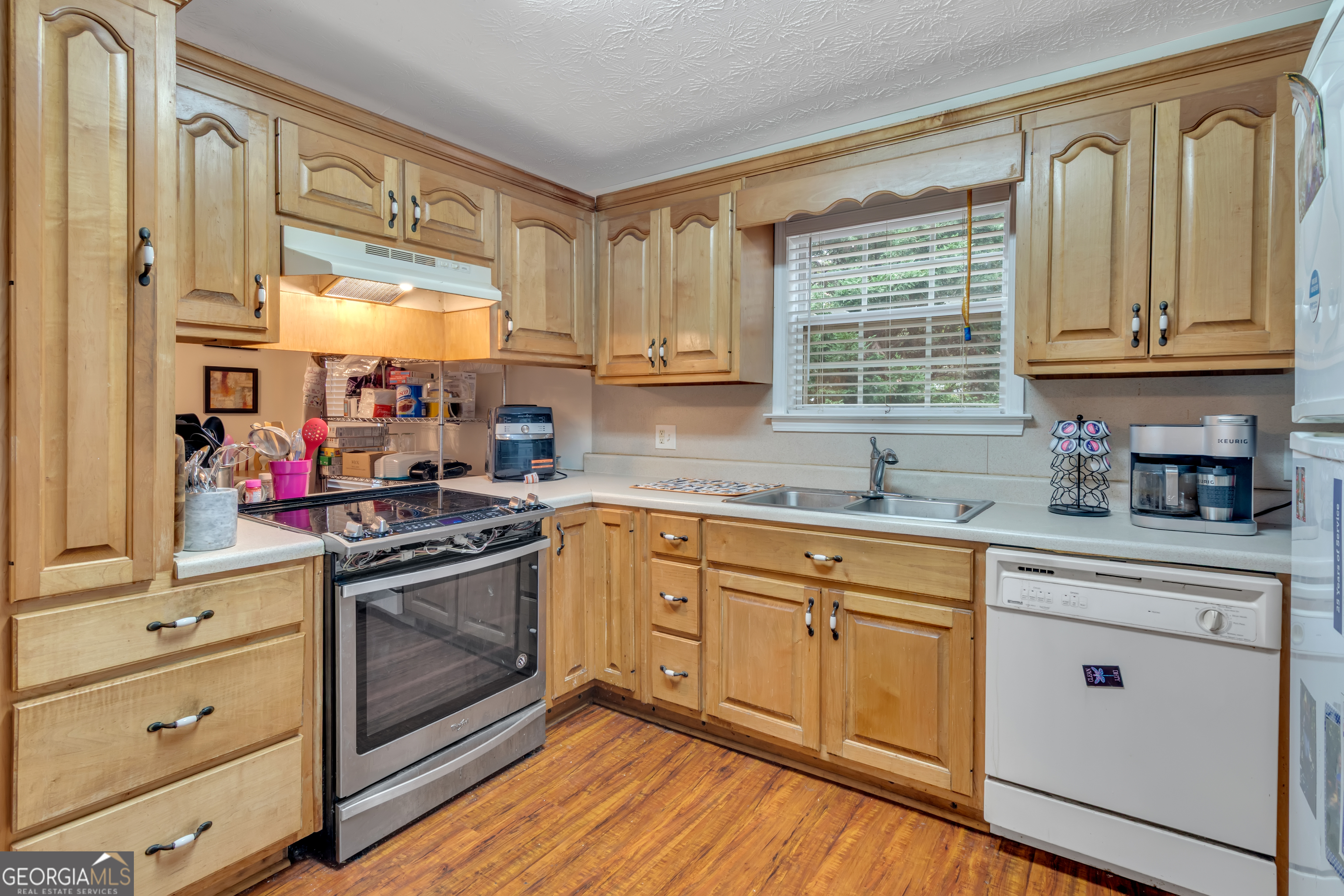 66 Ellis Trail Covington, GA 30016 - Photo 22 of 39 a kitchen with stainless steel appliances granite countertop a stove and white cabinets