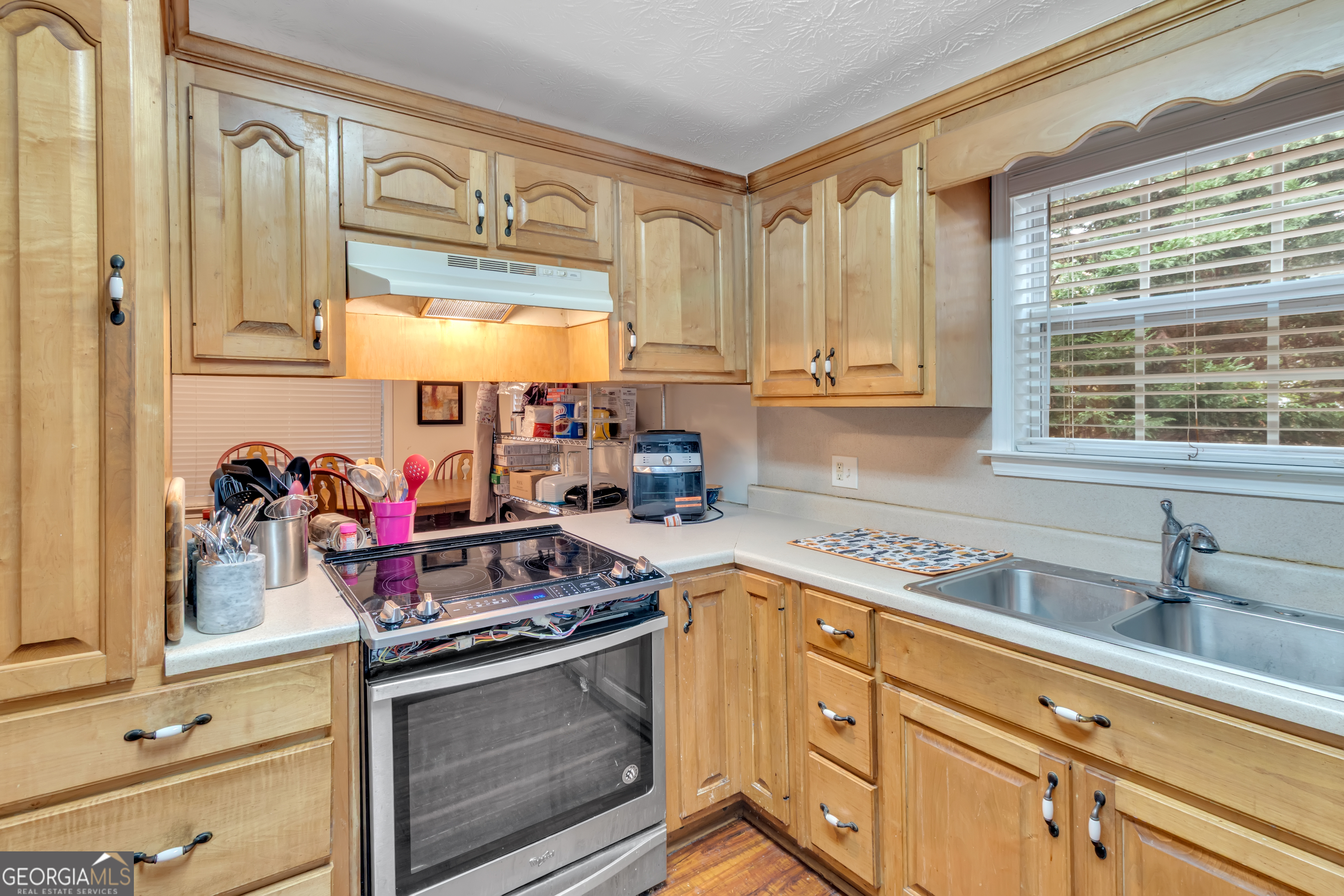 66 Ellis Trail Covington, GA 30016 - Photo 28 of 39 a kitchen with stainless steel appliances granite countertop a sink stove and cabinets