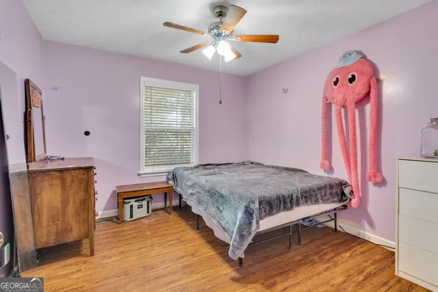 a spacious bedroom with a large bed a chandelier and windows