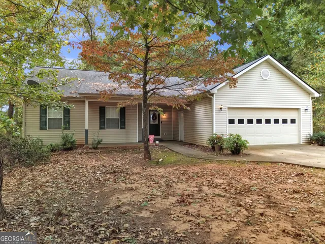 a view of a house with a yard and large tree