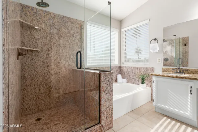 a bathroom with a granite countertop bathtub shower sink and mirror