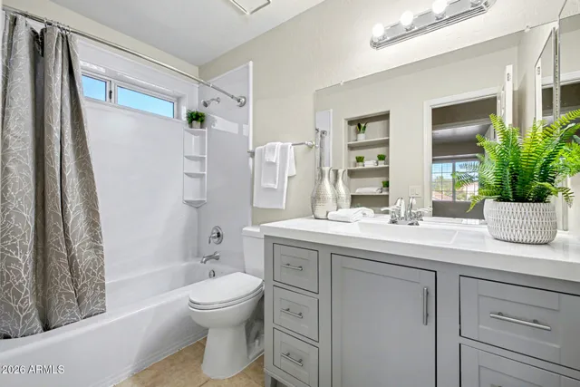 a bathroom with a granite countertop sink toilet a large mirror a shower and a bathtub