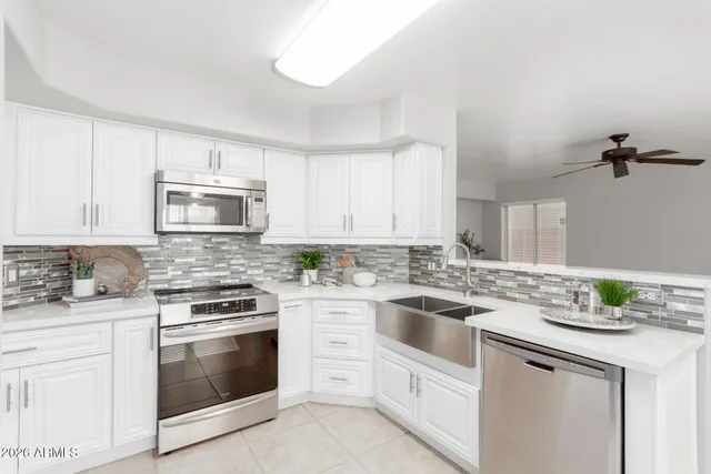 a kitchen with white cabinets appliances and sink