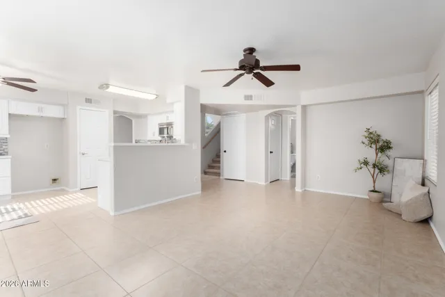 a view of empty room with wooden floor and ceiling fan