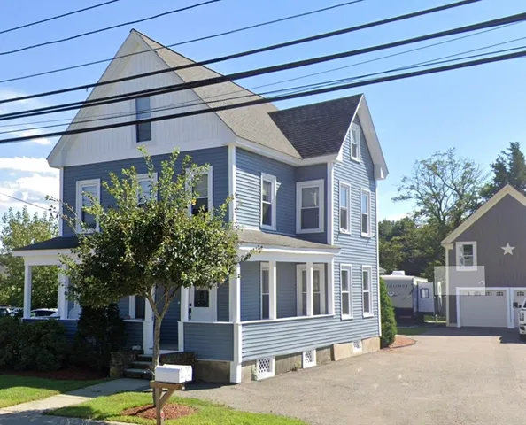 a front view of a house with a yard garage and outdoor seating