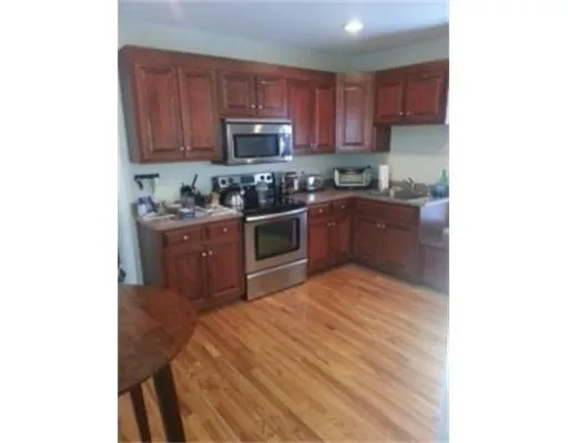 a kitchen with stainless steel appliances granite countertop a stove top oven a sink and a granite counter top