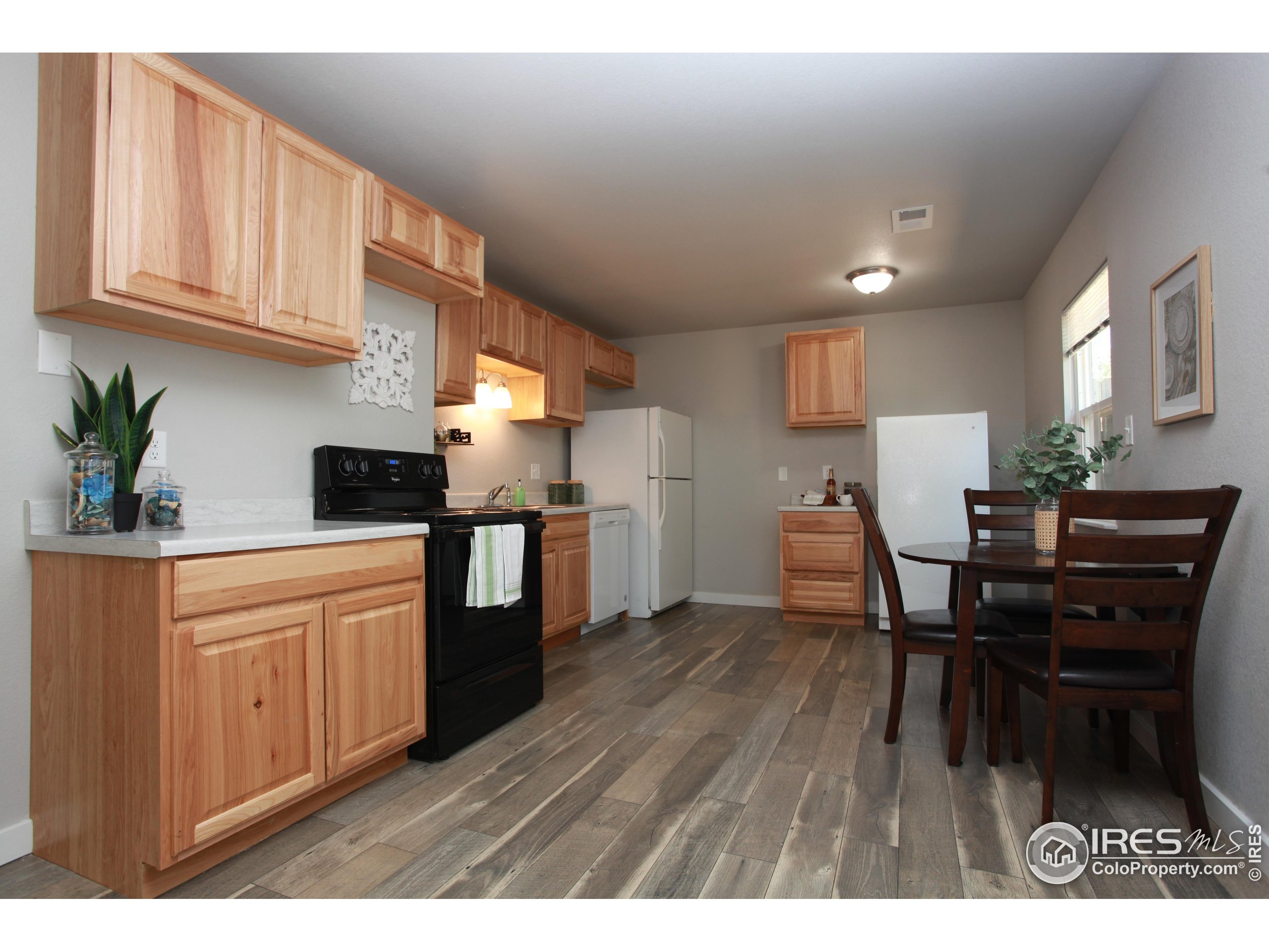 a kitchen with stainless steel appliances granite countertop wooden floors a dining table and chairs