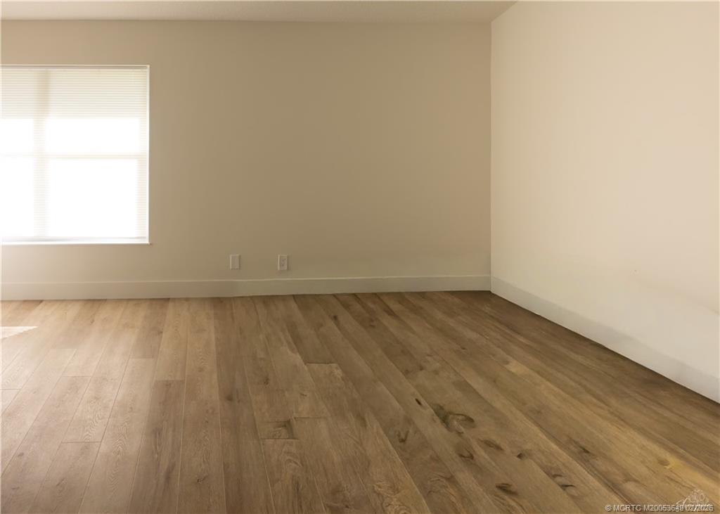2425 Southwest Foxpoint Trail Palm City, FL 34990 - Photo 13 of 31 an empty room with wooden floor and windows