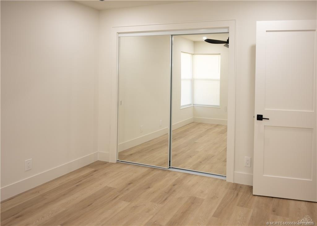 2425 Southwest Foxpoint Trail Palm City, FL 34990 - Photo 19 of 31 a view of an empty room with wooden floor and closet area
