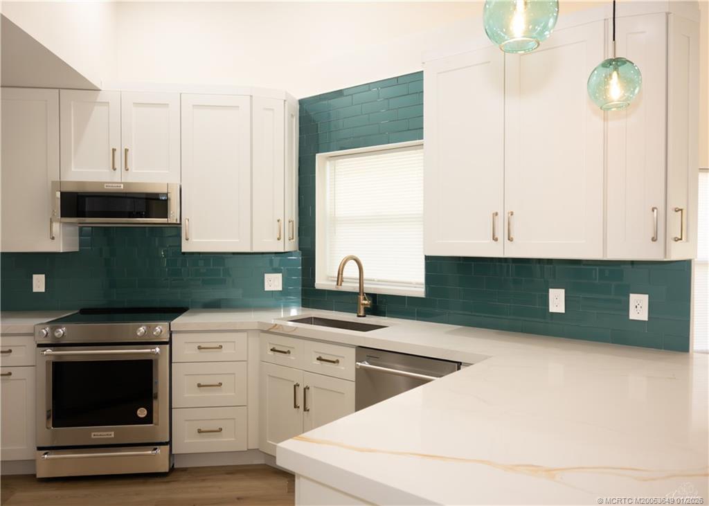 2425 Southwest Foxpoint Trail Palm City, FL 34990 - Photo 4 of 33 a kitchen with white cabinets and sink