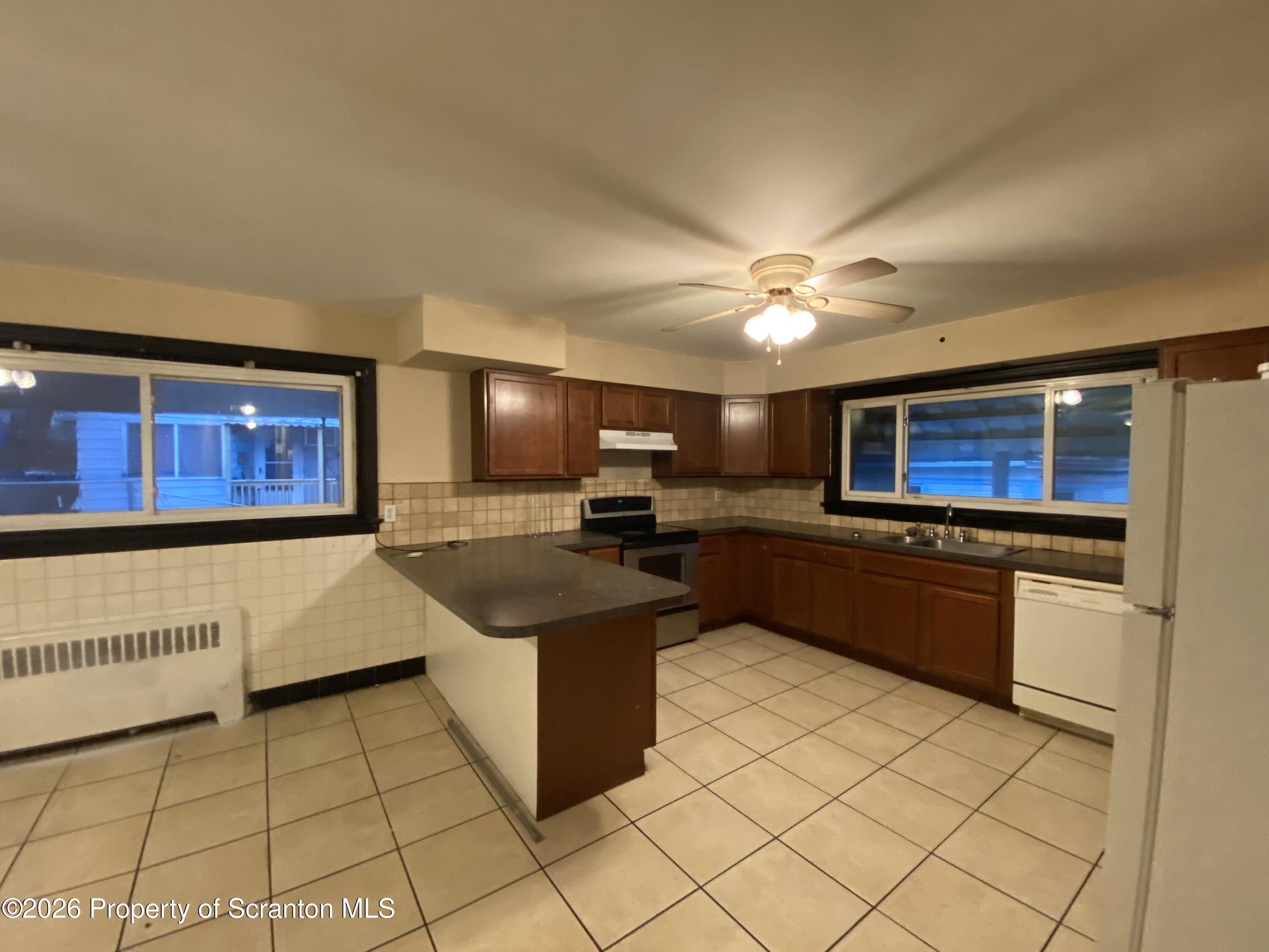 414 Orchard Street Scranton, PA 18505 - Photo 8 of 20 a kitchen with stainless steel appliances granite countertop a sink and cabinets
