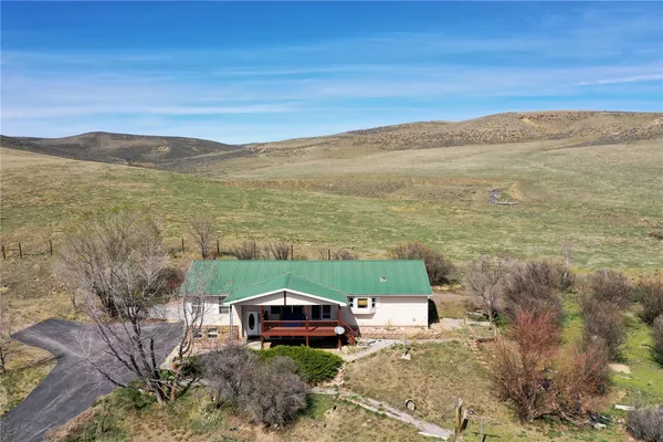 a front view of a house with a yard and mountain view