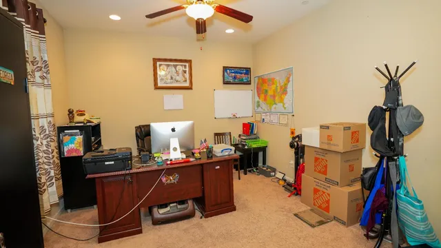 a view of a workspace with furniture and a window