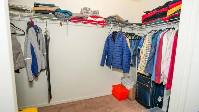a view of walk in closet with clothes and shoes