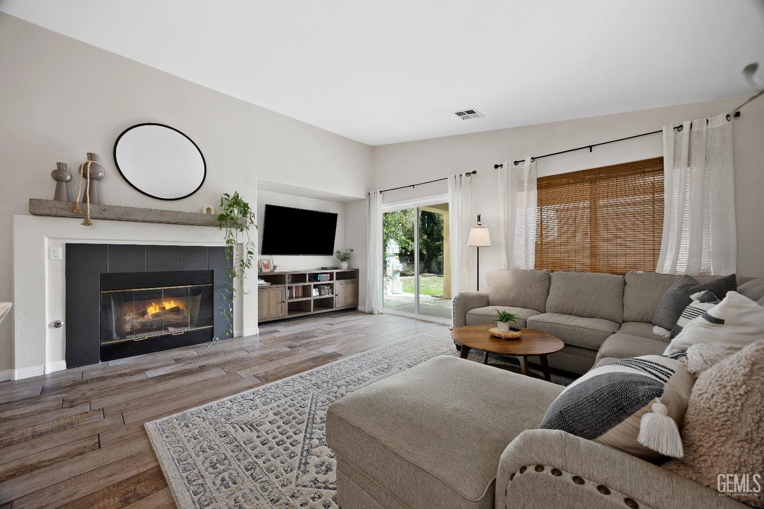Undisclosed Address Bakersfield, CA 93311 - Photo 12 of 30 a living room with furniture a flat screen tv and a fireplace