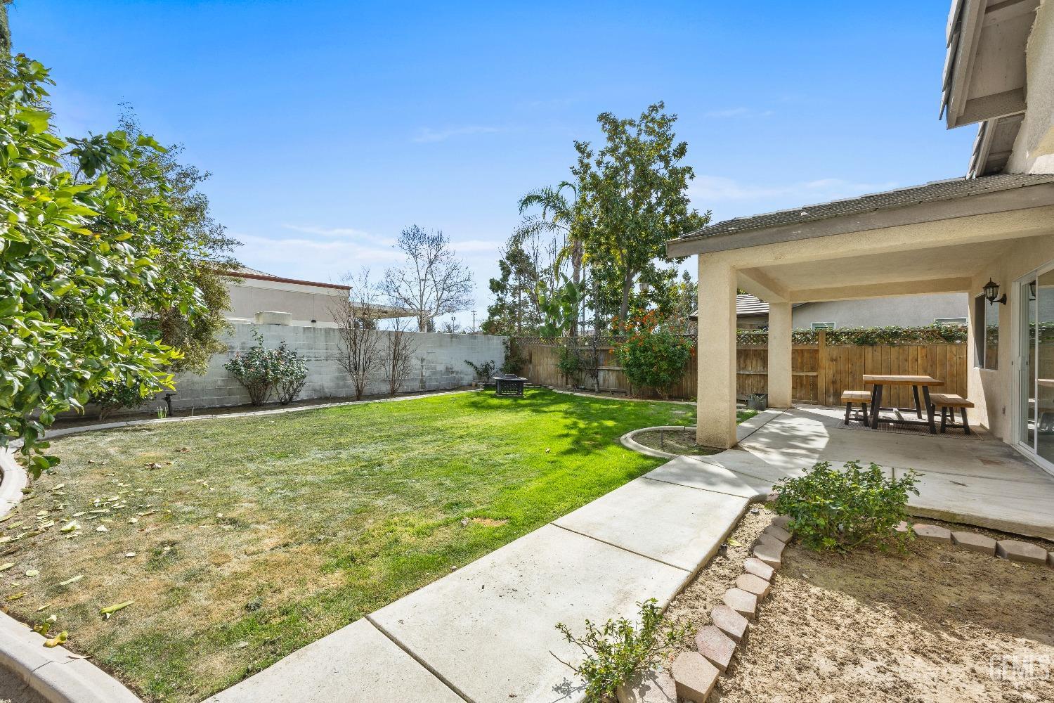 Undisclosed Address Bakersfield, CA 93311 - Photo 28 of 30 a view of a patio with table and chairs next to yard and a large tree