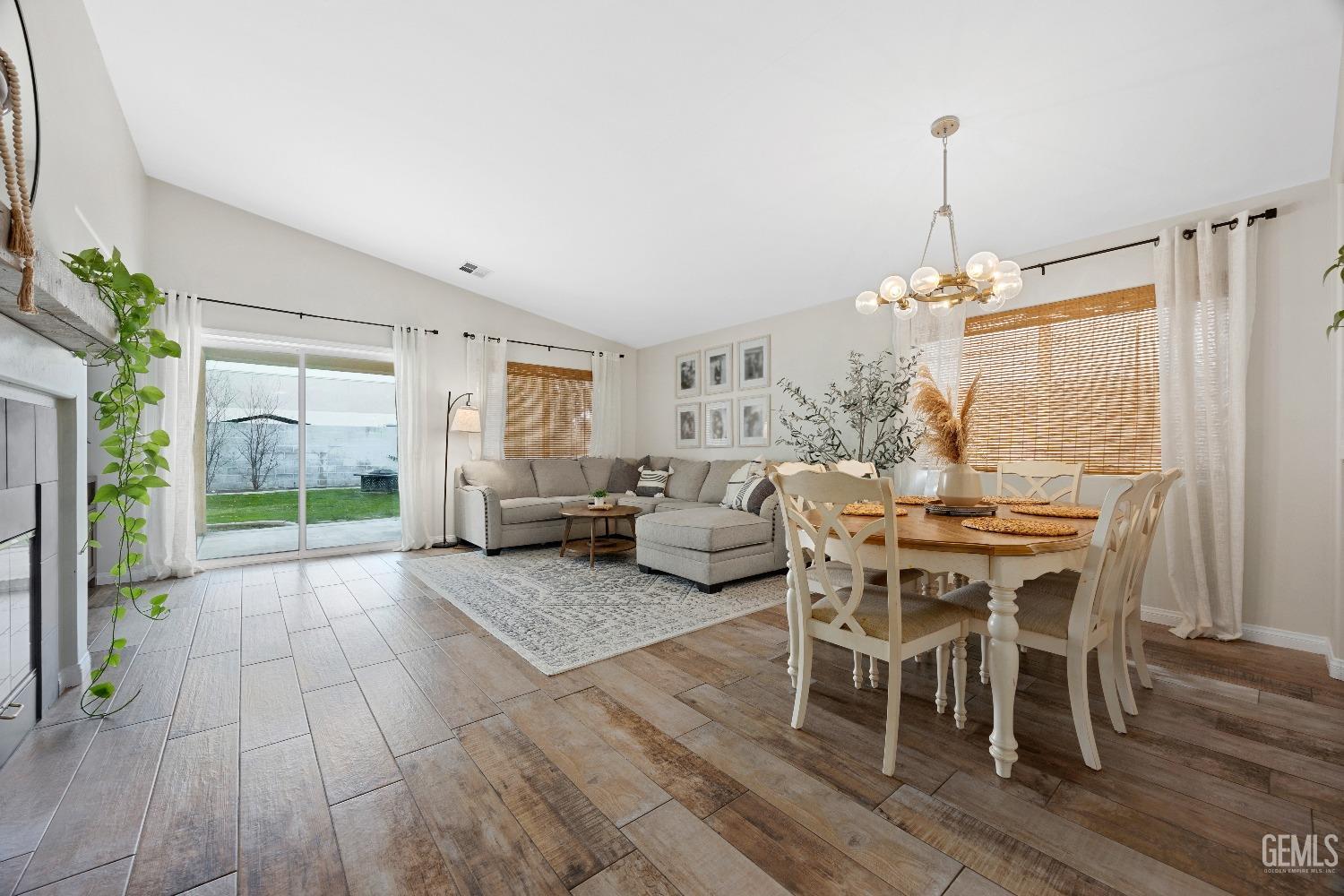 Undisclosed Address Bakersfield, CA 93311 - Photo 9 of 30 a view of a dining room and livingroom with furniture wooden floor a chandelier
