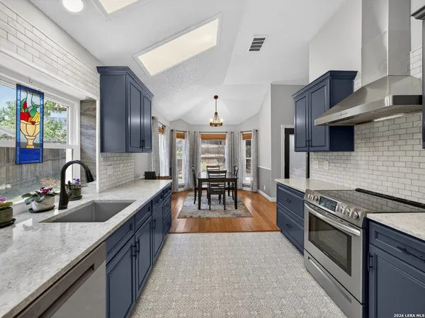 a kitchen with stainless steel appliances granite countertop a sink stove and cabinets