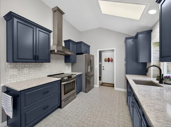 a kitchen with stainless steel appliances granite countertop a sink stove and refrigerator