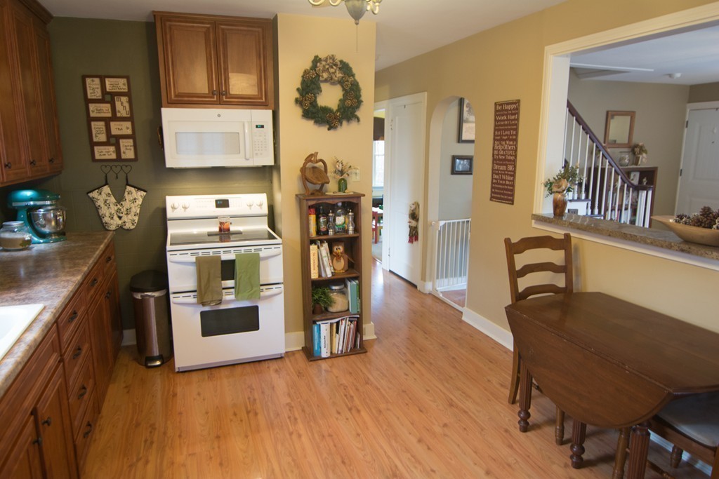 5 Farquhar Road Sturbridge, MA 01566 - Photo 11 of 27 a kitchen with stainless steel appliances granite countertop a refrigerator a stove top oven and a dining table with wooden floor