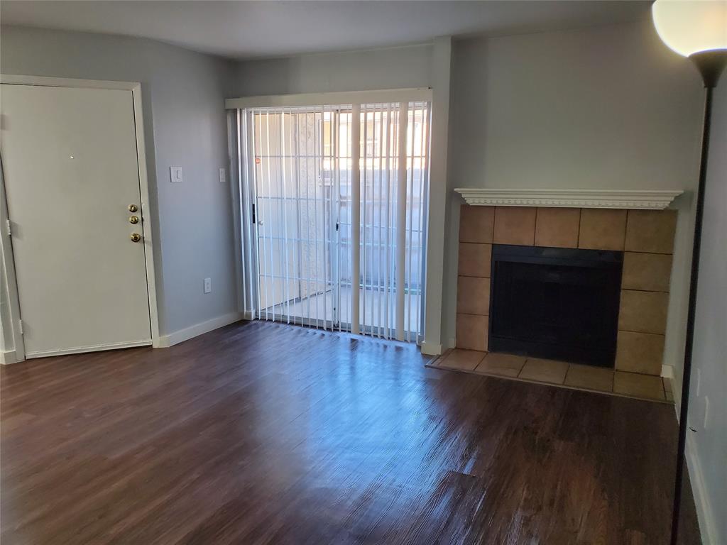 12482 Abrams Road, Unit 1402 Dallas, TX 75243 - Photo 3 of 32 an empty room with wooden floor and fireplace