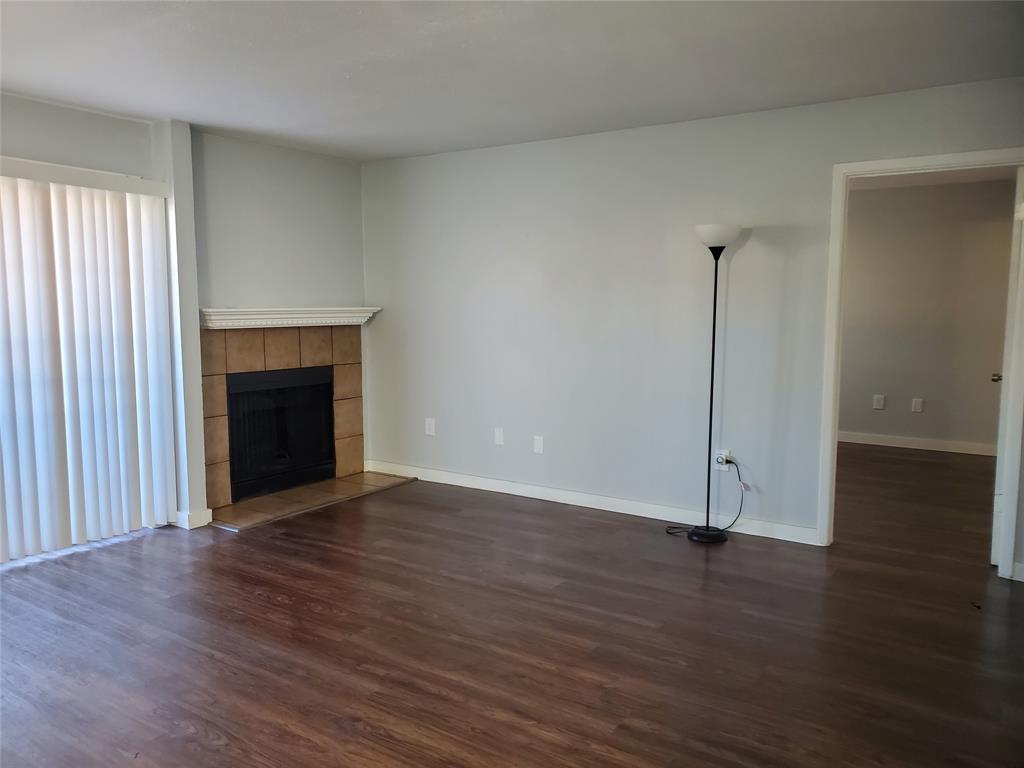 12482 Abrams Road, Unit 1402 Dallas, TX 75243 - Photo 4 of 32 an empty room with wooden floor fireplace and windows