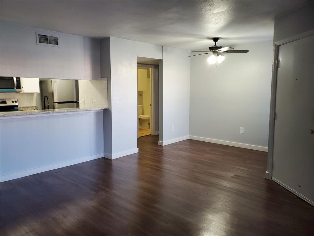 12482 Abrams Road, Unit 1402 Dallas, TX 75243 - Photo 5 of 32 a view of an empty room with wooden floor and a window