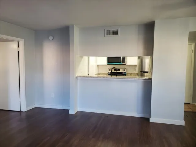 a kitchen with wooden floors and wooden cabinets