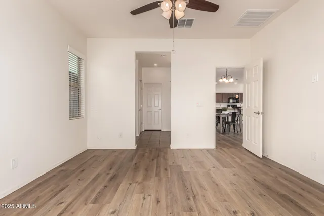 a view of a hallway with wooden floor and chandelier
