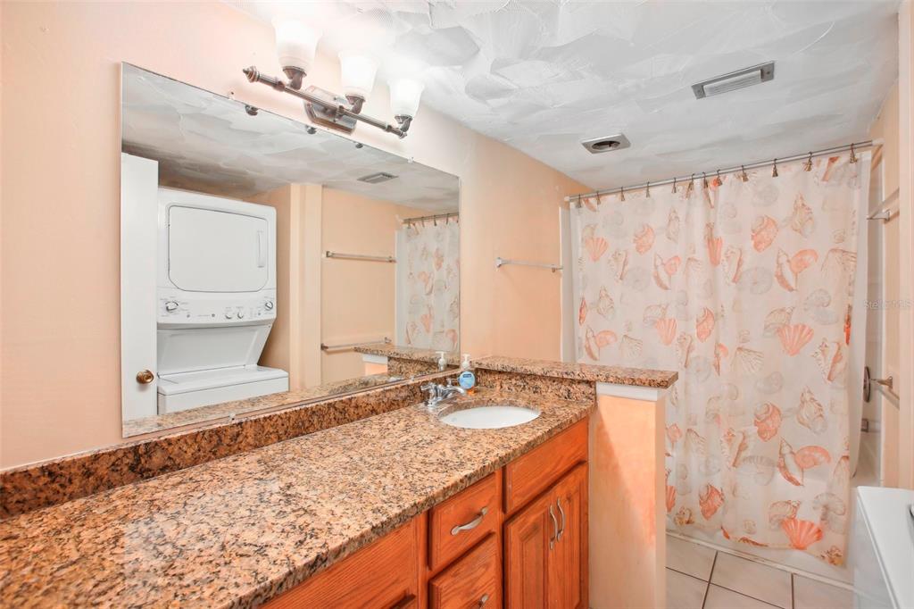343 Rex Place, Unit F Madeira Beach, FL 33708 - Photo 16 of 28 a bathroom with a granite countertop sink and a mirror