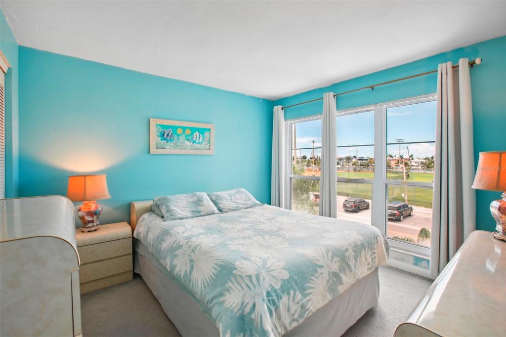 343 Rex Place, Unit F Madeira Beach, FL 33708 - Photo 18 of 28 a bedroom with a large bed and a large window
