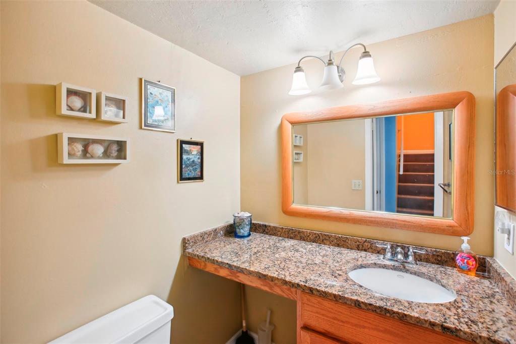 343 Rex Place, Unit F Madeira Beach, FL 33708 - Photo 19 of 28 a bathroom with a granite countertop sink and a mirror